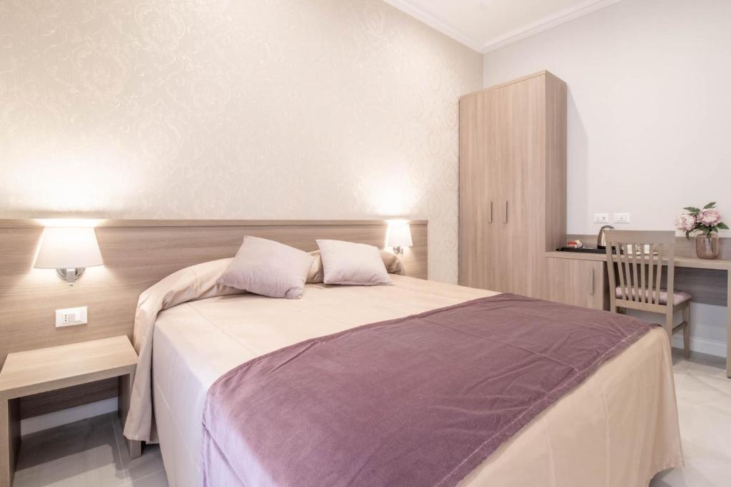 a bedroom with a large bed with two pillows at DANY GUEST HOUSE in Rome