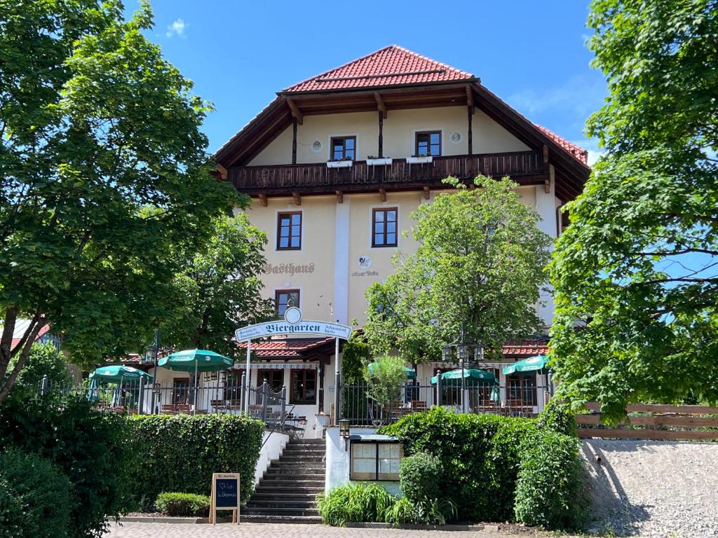 un bâtiment avec un escalier en face de celui-ci dans l'établissement Gasthaus Kampenwand Bernau, à Bernau am Chiemsee