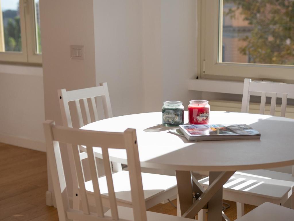 un tavolo bianco con sedie e due lattine di soda di Olimpico deluxe apartment a Roma