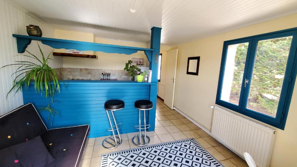 cocina con encimera azul y taburetes en una habitación en Hysope, en Château-Arnoux-Saint-Auban