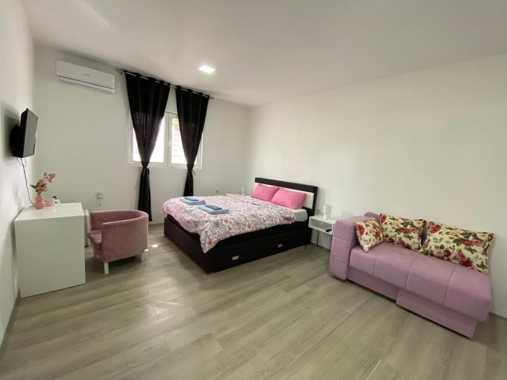 a bedroom with a bed and a couch at Apartmani Home in Zaječar