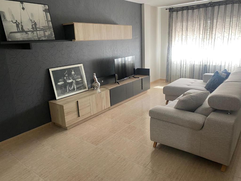 a living room with a couch and a tv at MEQUEDO GRAN CAMINANTE in Alcañiz