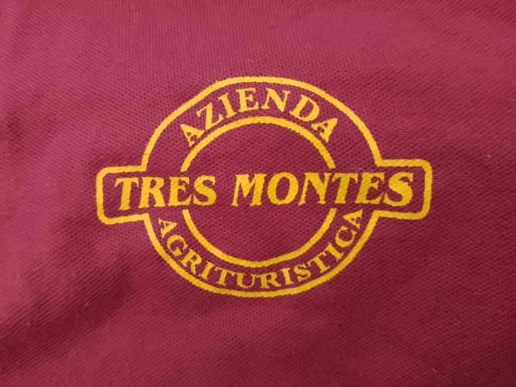 un logotipo amarillo en el lado de una camisa roja en Agriturismo Tres Montes, en Sorso