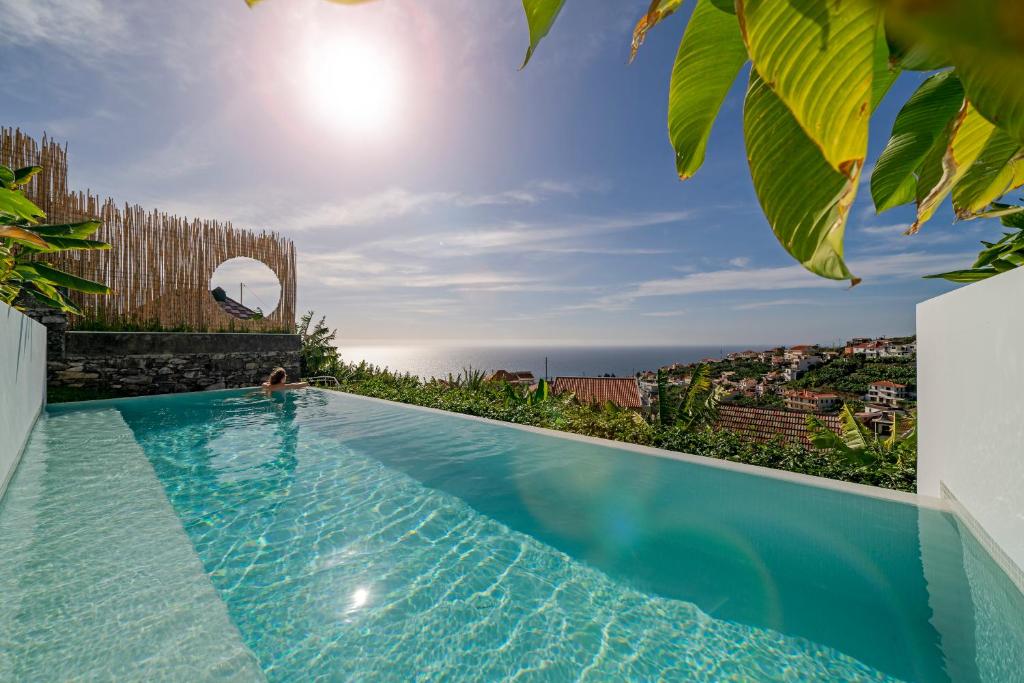 a swimming pool with a view of the ocean at Casas da Vargem shared swimming pool by An Island Apart in Ponta do Sol