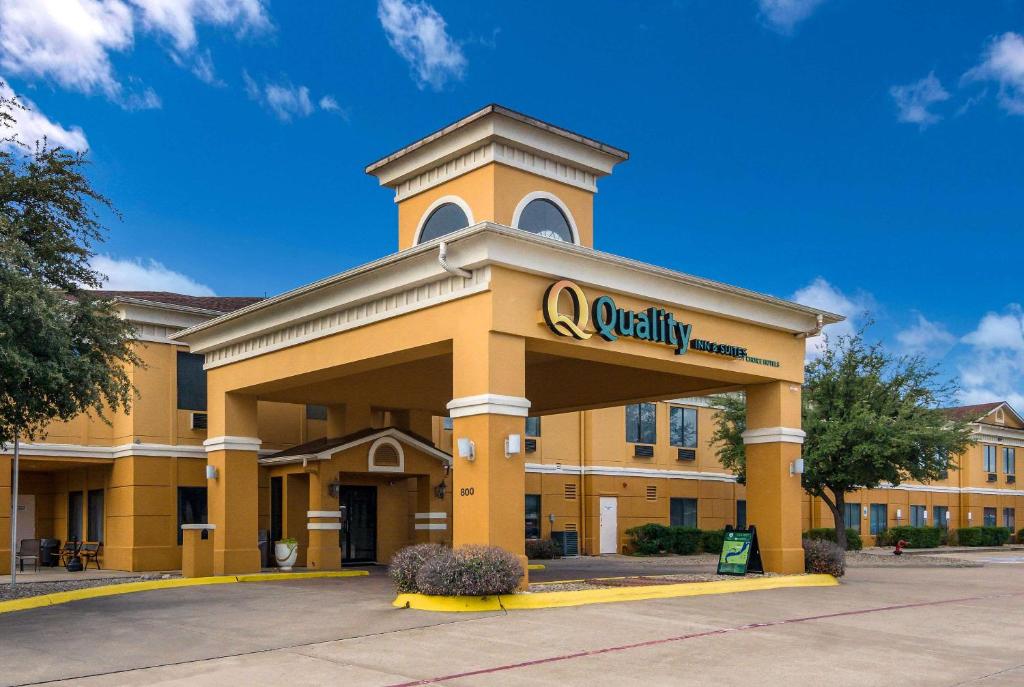 ein gelbes Gebäude mit einem Hochschulschild drauf. in der Unterkunft Quality Inn & Suites Granbury in Granbury