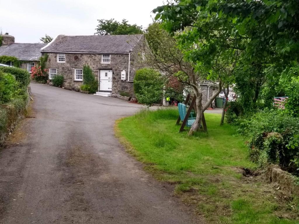 une route vide devant une maison dans l'établissement Pandy cymunod, à Bryngwran