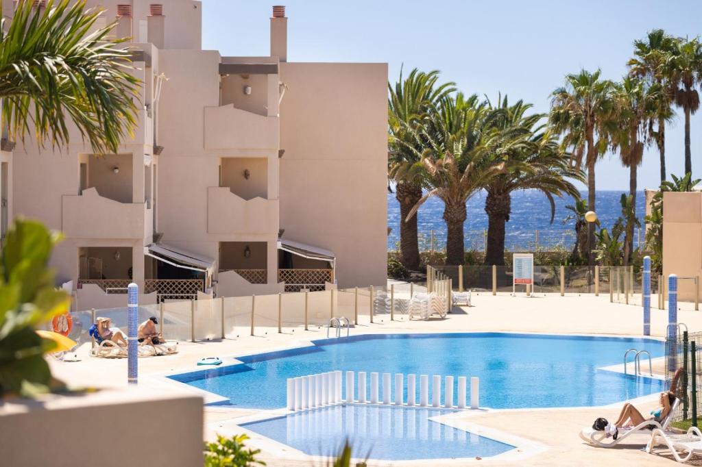 a view of the pool at a resort with palm trees at Apartamento Sotavento I (RM) in El Médano