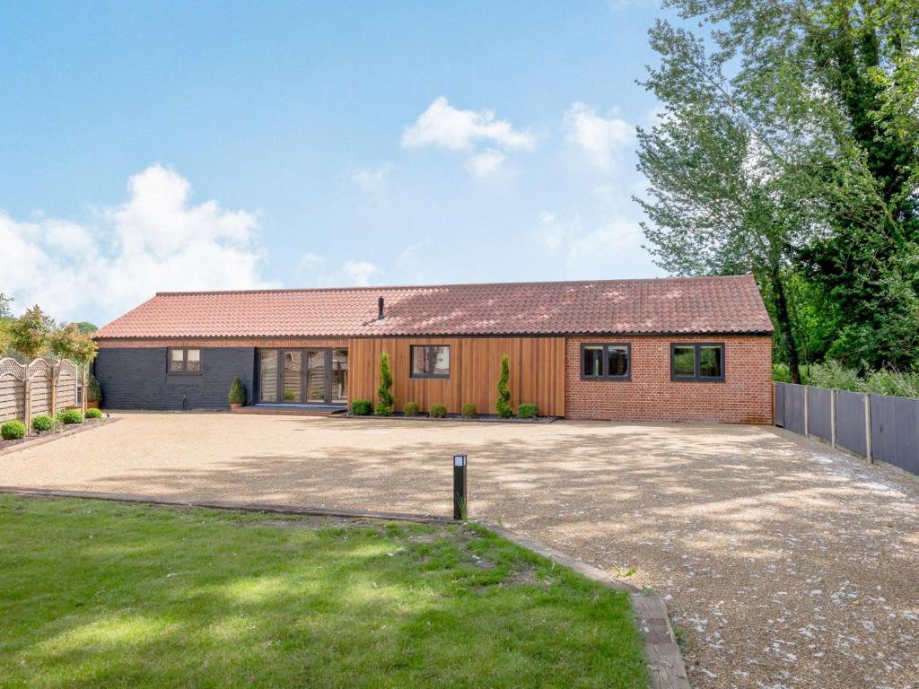 a house with a large driveway in front of it at The Gallery Barn - Uk39368 in Swafield