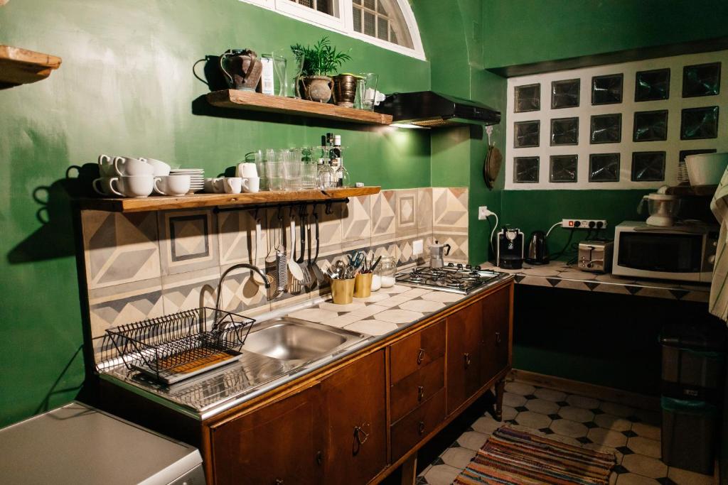 ナポリにあるGreen Chiaiaの緑の壁のキッチン(シンク付)
