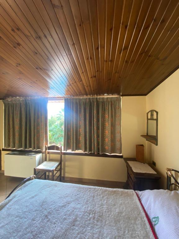 a bedroom with a large bed with a wooden ceiling at Villa Castello Andria in Castel del Monte