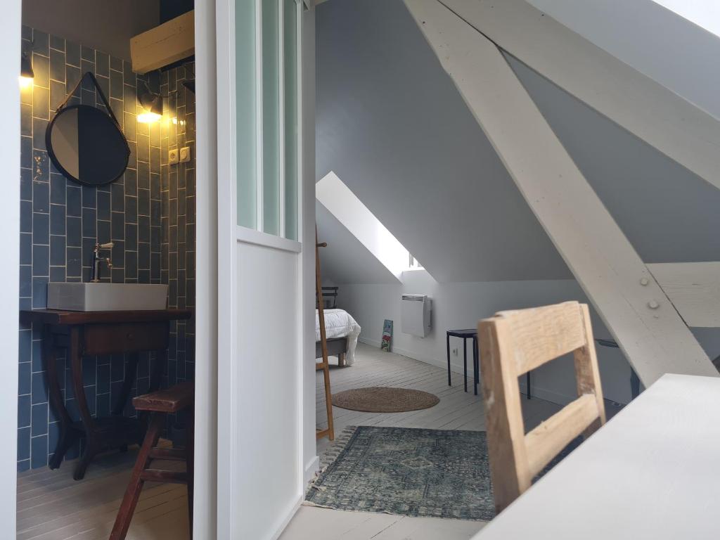 a room with a staircase with a table and a chair at Les 3 Graces, Cayeux-sur-mer, agréable maison in Cayeux-sur-Mer
