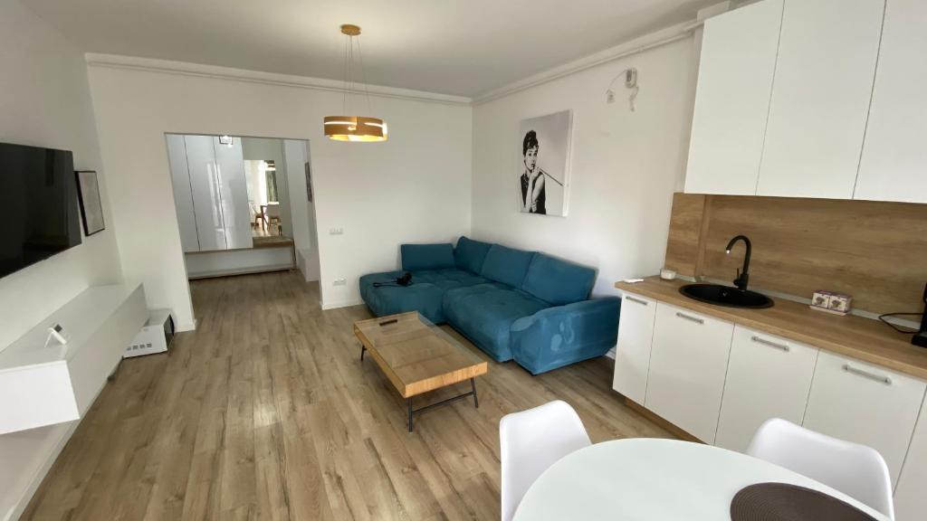 uma sala de estar com um sofá azul e uma cozinha em Eclipse Residence 1 em Baia Mare