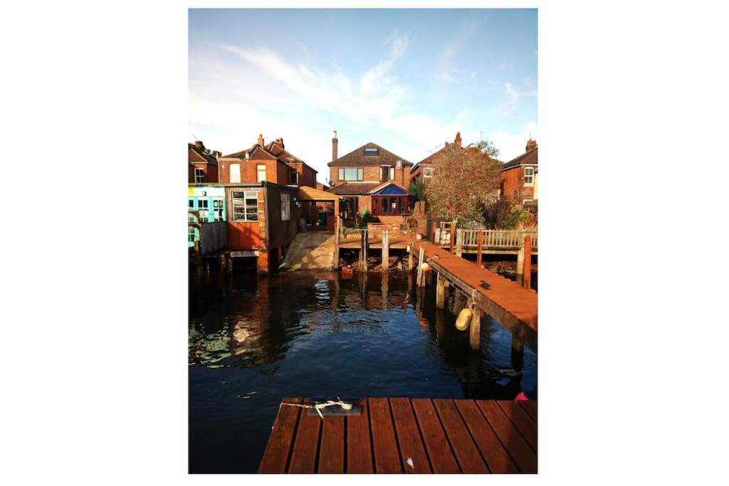a view of a river with houses and a dock at The Retreat, a Luxury Riverside Cottage & garden in Southampton