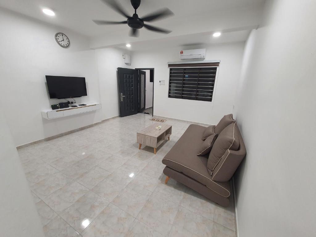a living room with a couch and a ceiling fan at Voon 2 bedroom homestay in Mersing