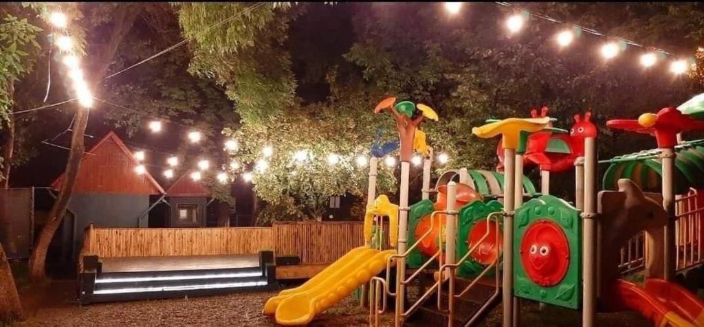 un parque infantil con un tobogán por la noche con luces en Complex Popas Pacurari, en Iaşi