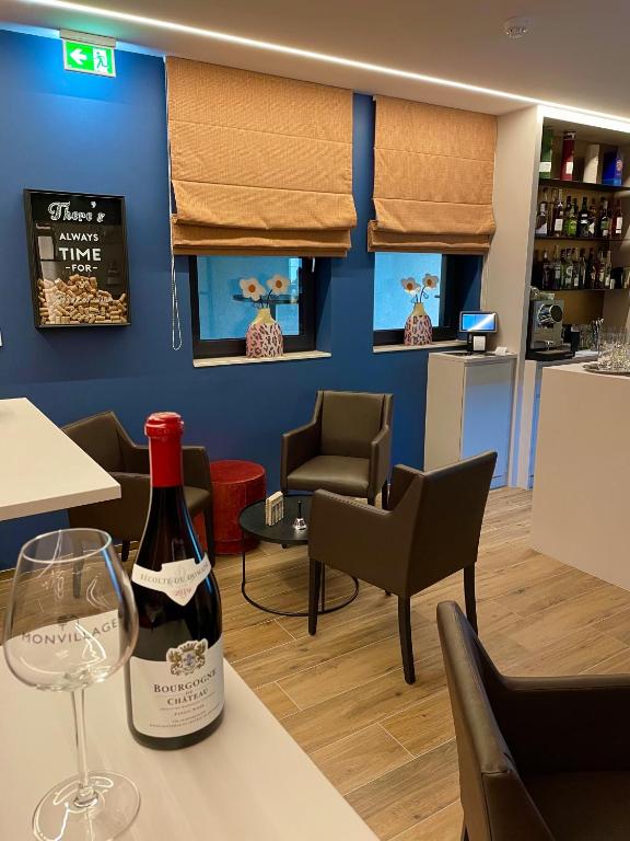 a bottle of wine sitting on a table in a restaurant at Hotel Monvillage in Mondercange