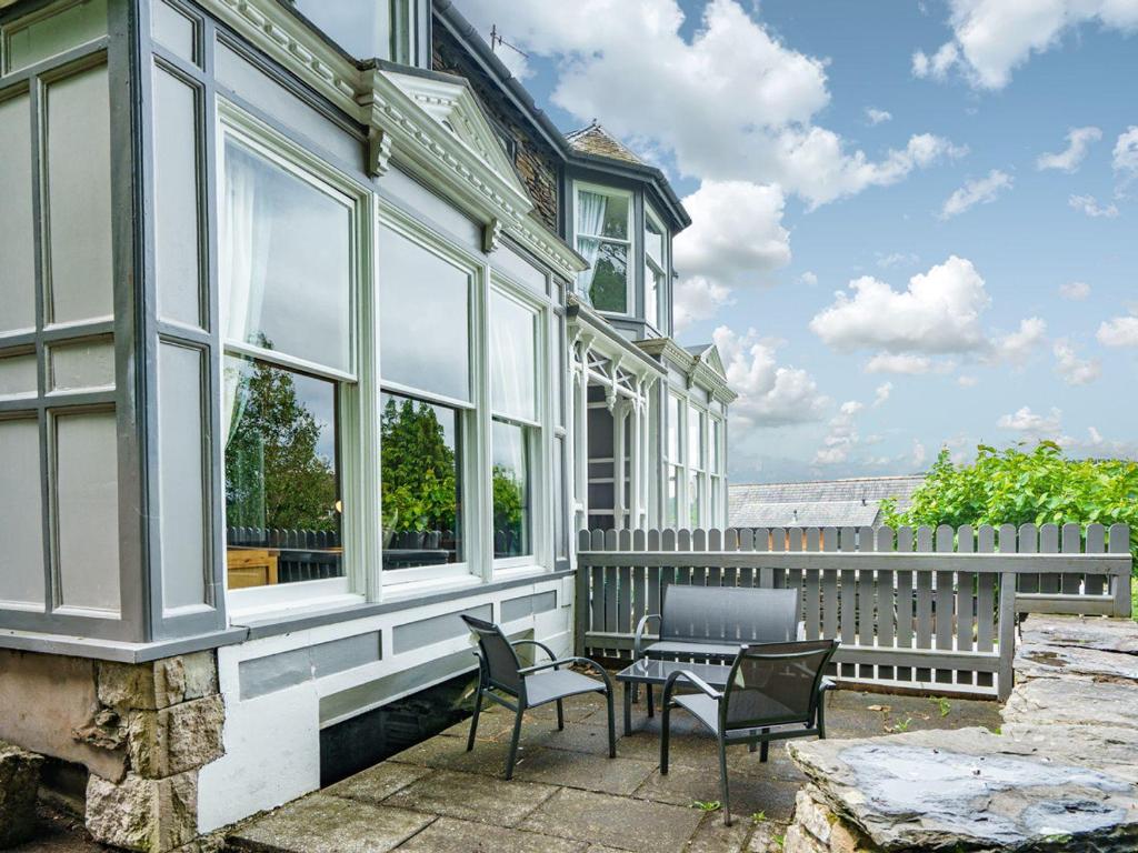 Cette maison dispose d'une terrasse avec des chaises et une table. dans l'établissement Gorgeous cottage in Bowness, à Bowness-on-Windermere