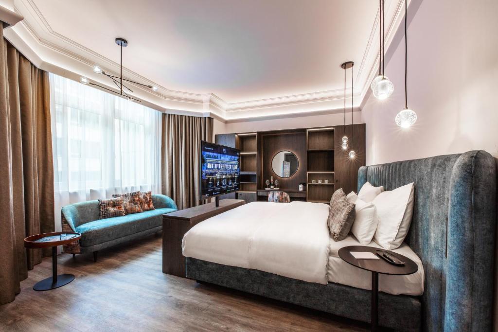 a hotel room with a bed and a couch at O11 Boutique Hotel Vienna in Vienna