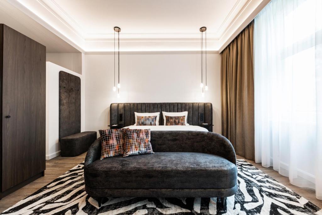 a bedroom with a bed and a couch at O11 Boutique Hotel Vienna in Vienna