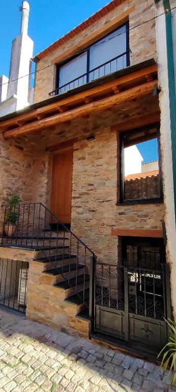 a brick building with stairs on the side of it at Casa d´ Avó Glória in Alvoco das Várzeas