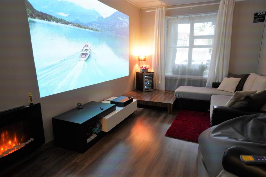 ein Wohnzimmer mit einem großen Bildschirm mit einem Boot an der Wand in der Unterkunft Hotelli mugavustega korter Vanalinna südames in Tallinn
