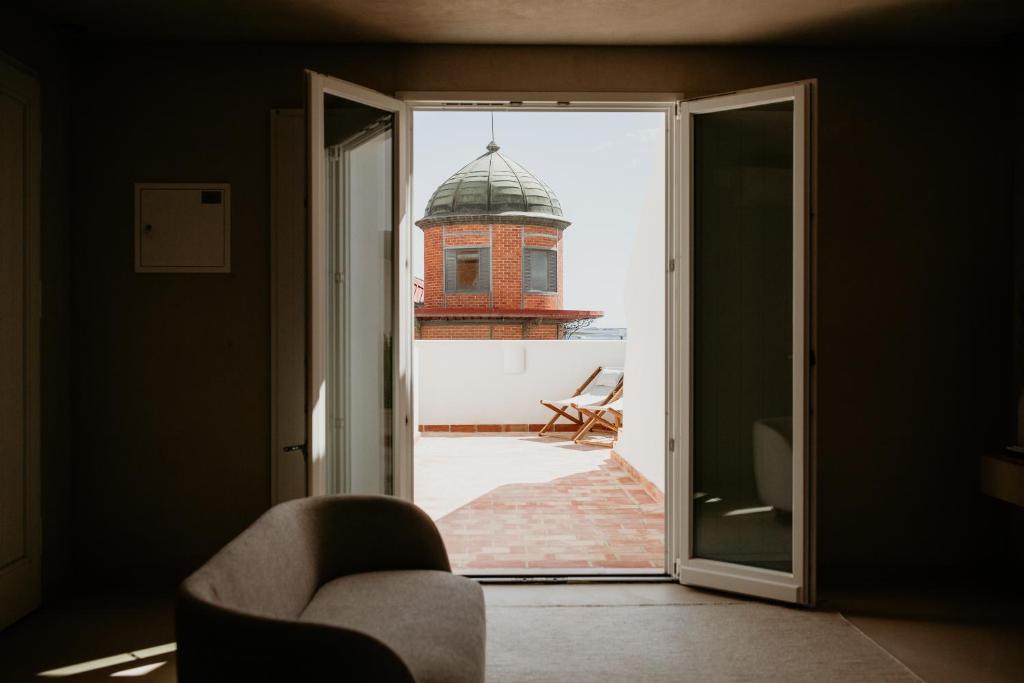 um quarto com uma porta aberta para uma vista de um edifício em Casa dos Mercados em Olhão