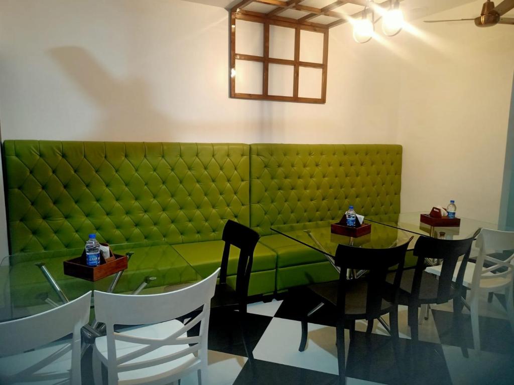 a dining room with a green couch and a table at VIAN INN in Guwahati