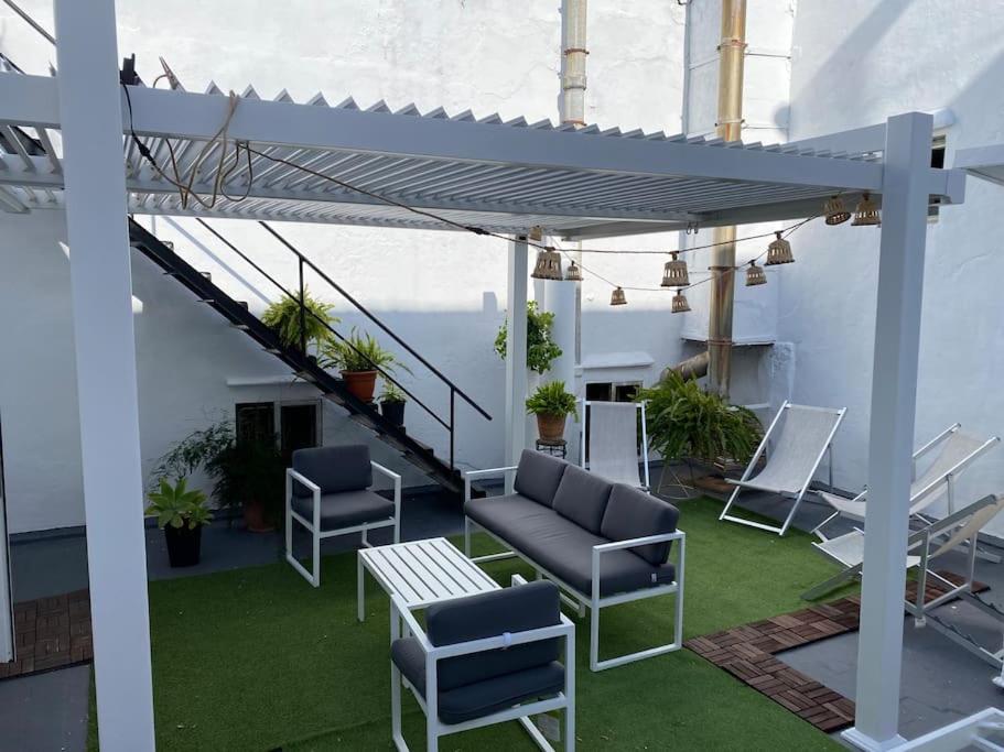 patio z krzesłami i stołem w budynku w obiekcie Gran casa señorial de 300m en centro histórico w mieście El Puerto de Santa María