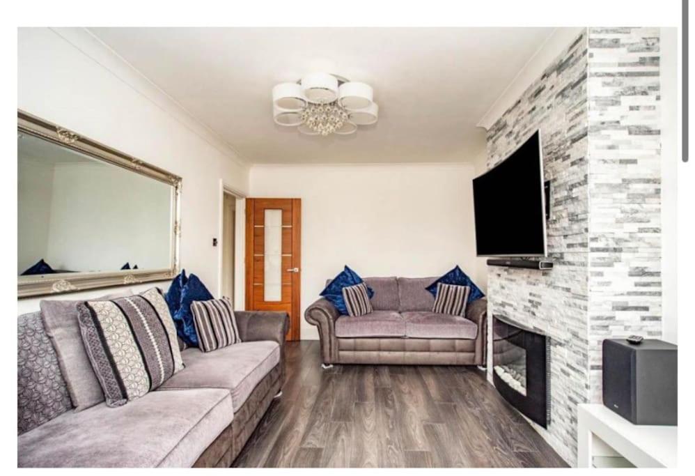 - un salon avec un canapé et une cheminée dans l'établissement 2 Bed - walking distance to Harry Potter Studio, à Leavesden Green