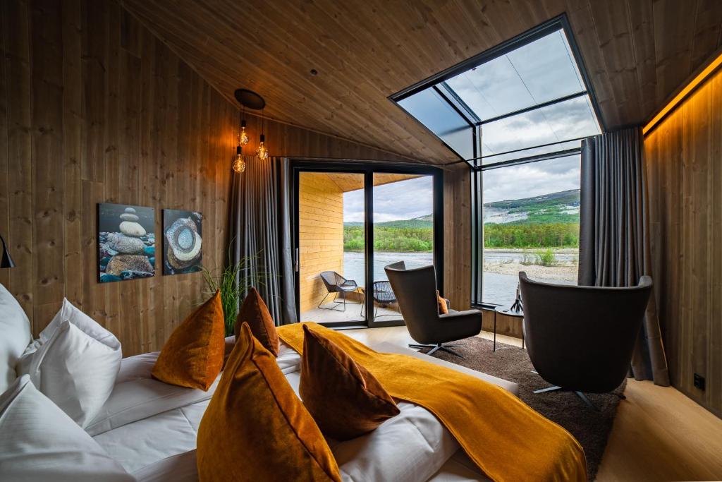 a bedroom with a bed and a large window at Sorrisniva Arctic Wilderness Lodge in Alta