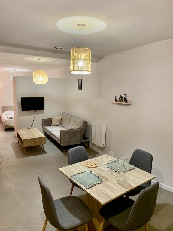 a living room with a table and chairs and a couch at Perpignan - Appartement en centre ville in Perpignan