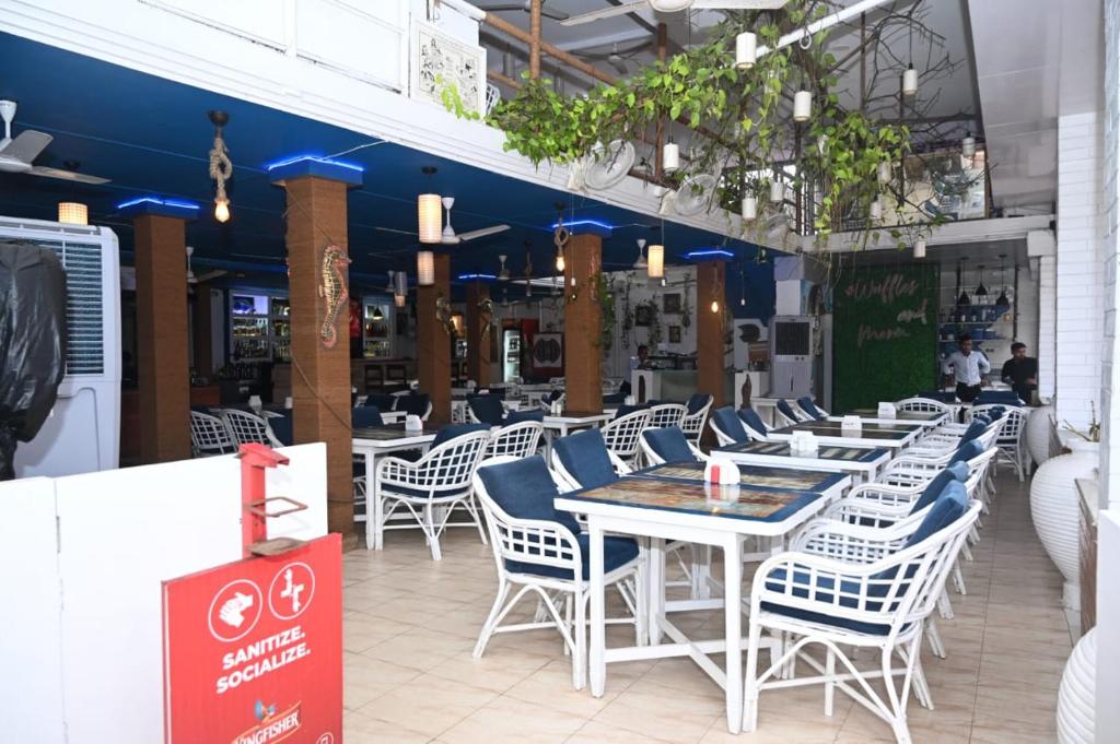 um grupo de mesas e cadeiras num restaurante em Coco homes by myroom em Candolim