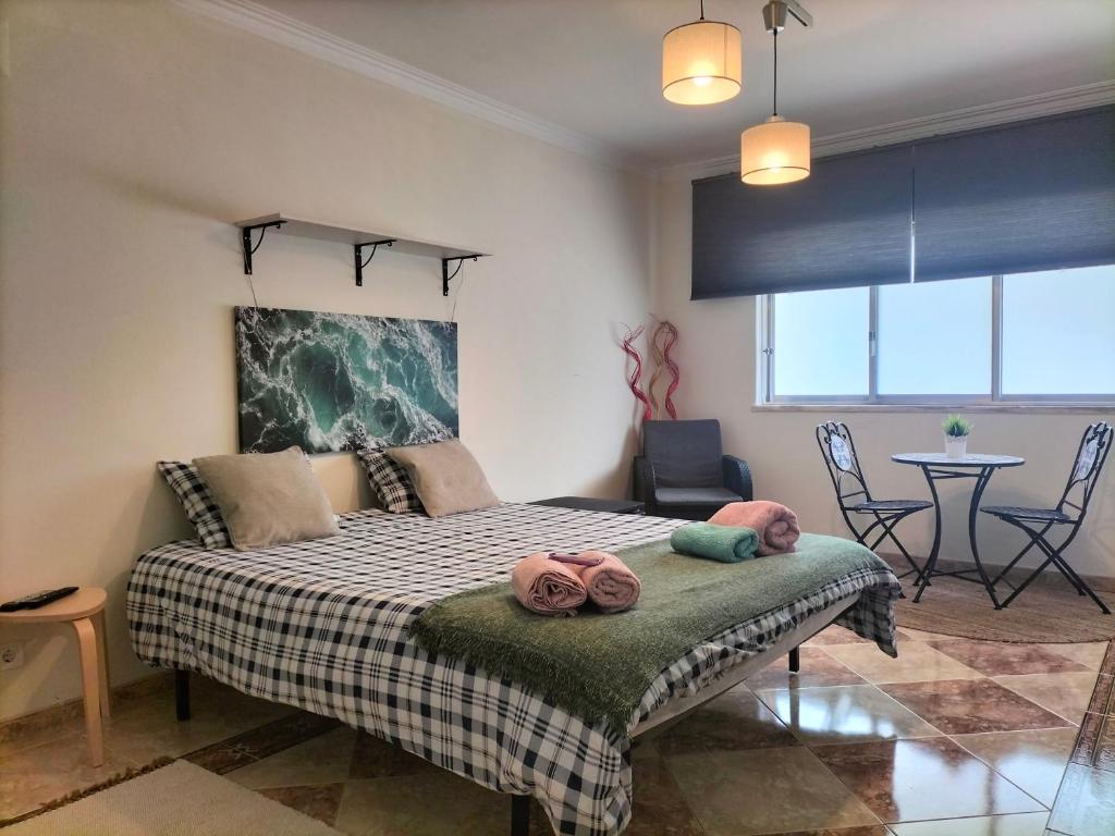 a bedroom with a bed with towels on it at Guest House Patrocinio in Corroios