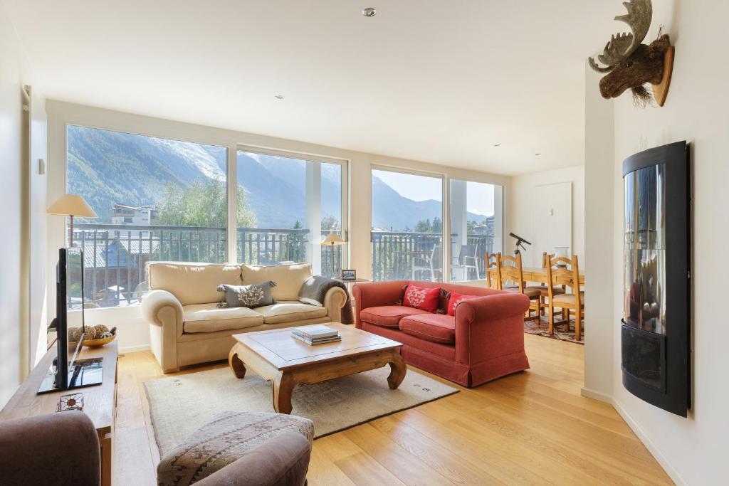 a living room with couches and a tv and a table at Résidence La Vallée Blanche - Happy Rentals in Chamonix-Mont-Blanc