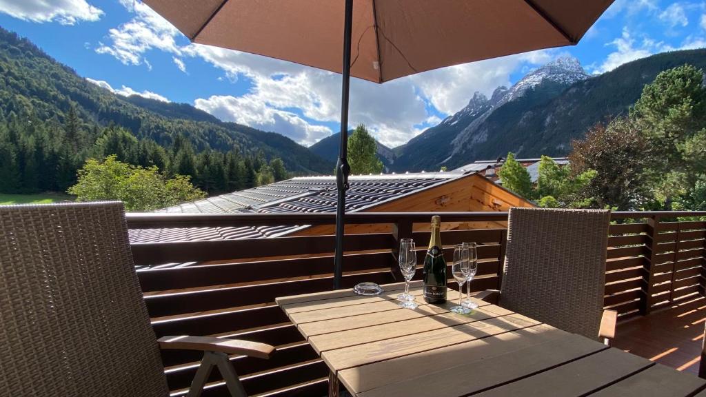 a wooden table with an umbrella on a balcony at Karwendel Apartments II in Scharnitz