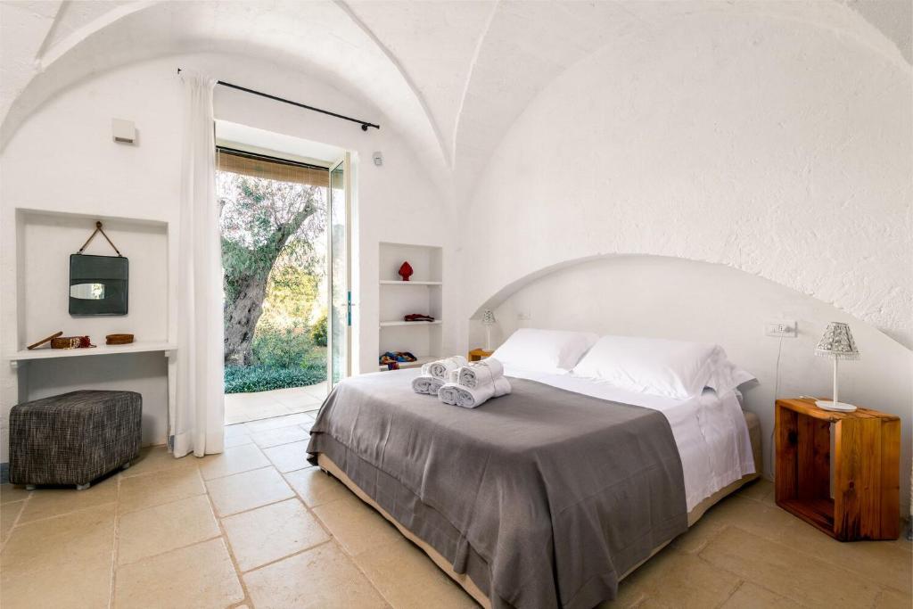 Dormitorio blanco con cama y ventana grande en Profitez de trois cents mètres à pied de l'accès à la mer et des restaurants, en Cassis