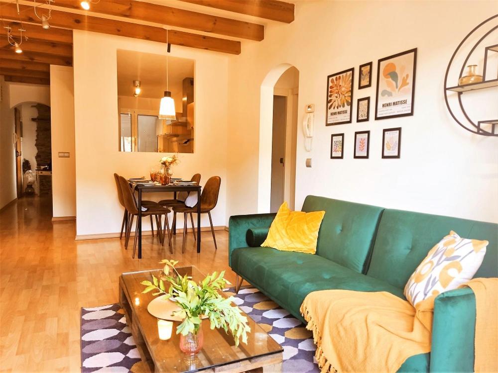 uma sala de estar com um sofá verde e uma mesa em Noa Apartment En el corazón de los Pirineos em Adrall