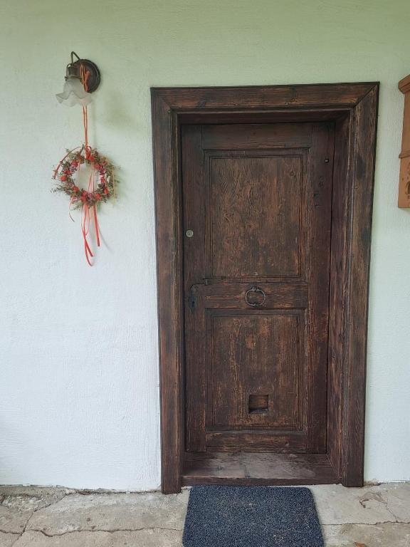 a wooden door with a wreath on a wall at Kellerstöckl Berg 106 in Strem
