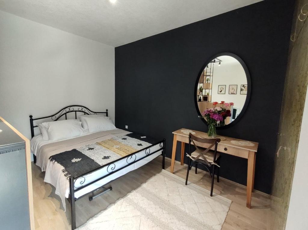 a bedroom with a bed and a mirror and a table at Katerina's Apartment in Bitola