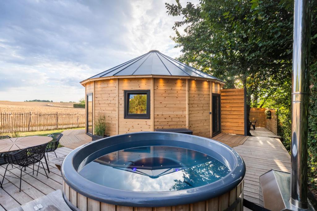 a large hot tub on a deck with a house at Le Scandin'Havre in Hannut