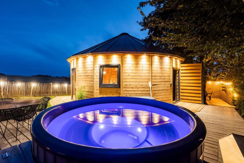 a large hot tub in front of a wooden house at Le Scandin'Havre in Hannut