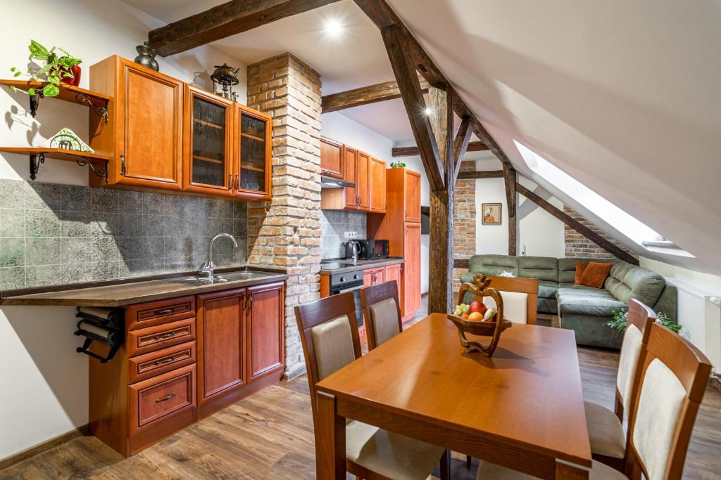 eine Küche und ein Esszimmer mit einem Holztisch in der Unterkunft Apartmány in Veritas in Mikulov