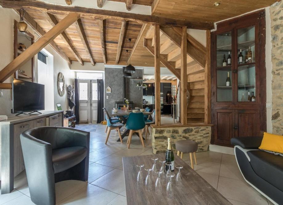 a kitchen and living room with a table and chairs at gite cosy et moderne au coeur des pyrénées 