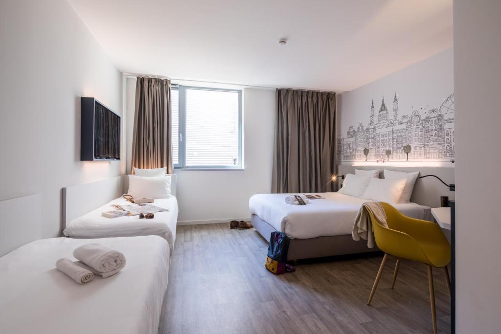 a hotel room with two beds and a tv at B&B Hotel Budapest City in Budapest