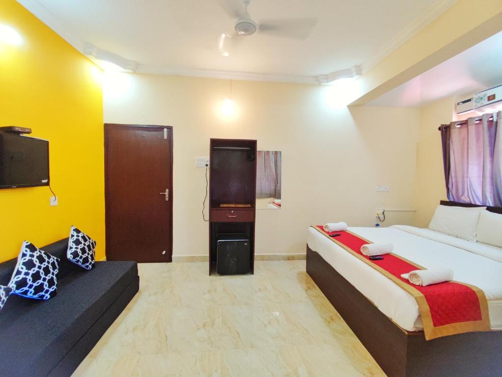 a bedroom with a large bed and a tv at Hotel Candolim Aloft in Candolim
