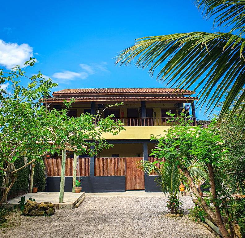 une maison avec un palmier devant dans l'établissement Suítes The Search Ubatuba Surf - Maranduba, à Ubatuba