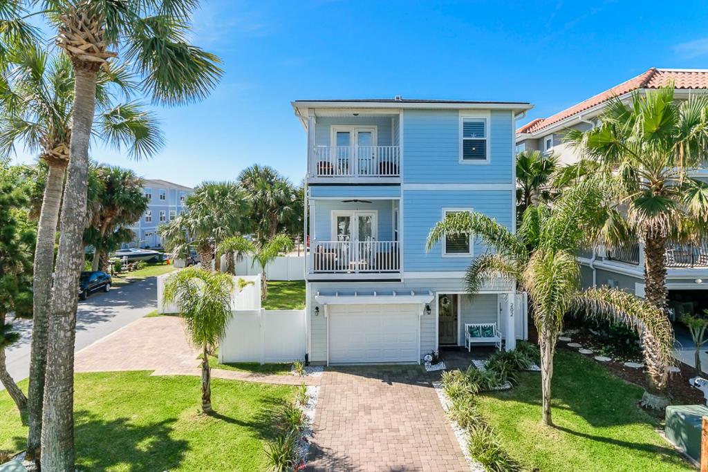 a blue house with palm trees in front of it at Near The Mayo Clinic 2 Blocks From Ocean 4 Bedroom Pet Friendly Home in Jacksonville Beach