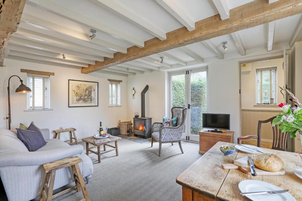 a living room with a couch and a table at Ostlers Loft in Chipping Campden