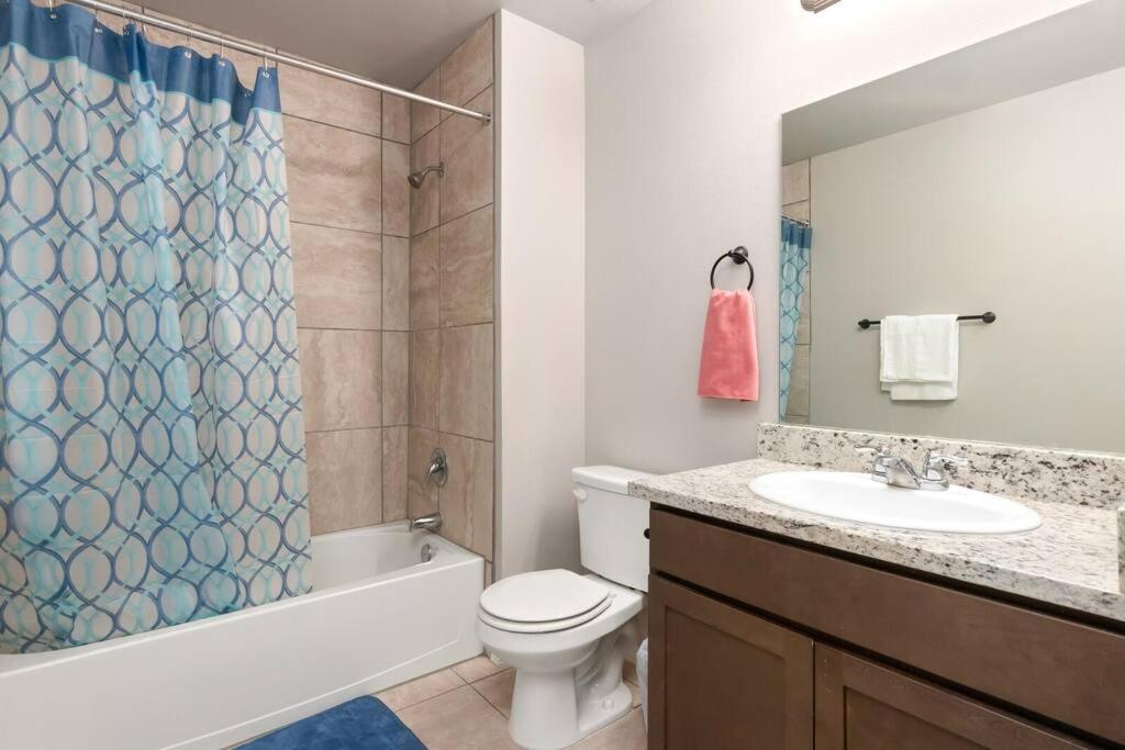 uma casa de banho com um WC, um lavatório e um chuveiro em Belair Lux 3BR 3BA Home W Private Hot tub, 3k Arcade Games & private garage- 5mins to the Airport em San Antonio