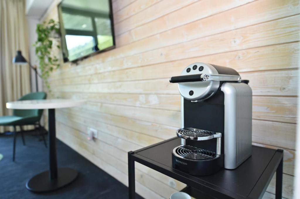 a coffee maker sitting on a table in a room at Pensiunea Atra Doftana in Teşila